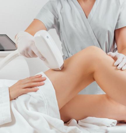 Laser hair removal on a patient’s leg at a dermatology clinic for smooth, hair-free skin.