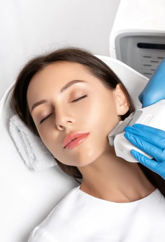 Non-invasive skin tightening treatment on a woman's face at a dermatology clinic for youthful, firm skin.